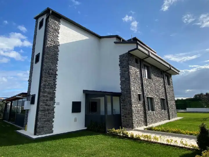 Beyaz villanın köşe kütlesinde antrasit kültür taşı kaplama