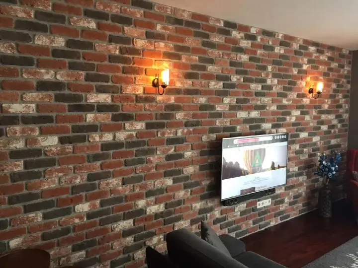 Duvar aplikleriyle aydınlanan koyu tonlu tuğla TV duvarı