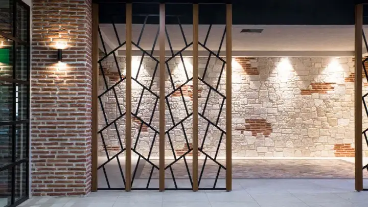 İç mekânda kırmızı tuğla kolon, taş duvar ve ahşap-metal paravan