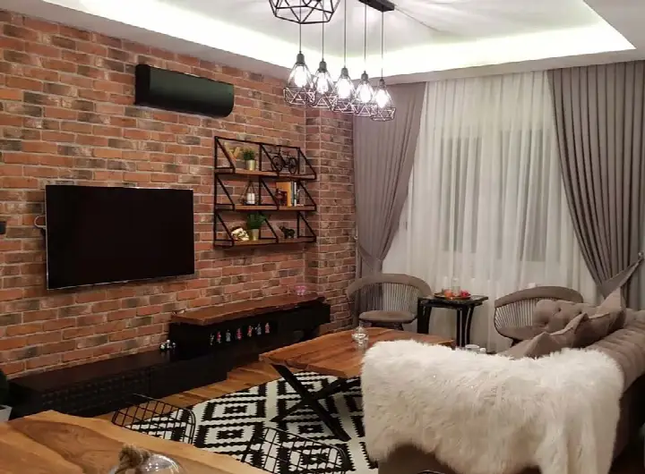 Salonda klimanın altında kırmızı tuğla TV duvarı ve sehpa